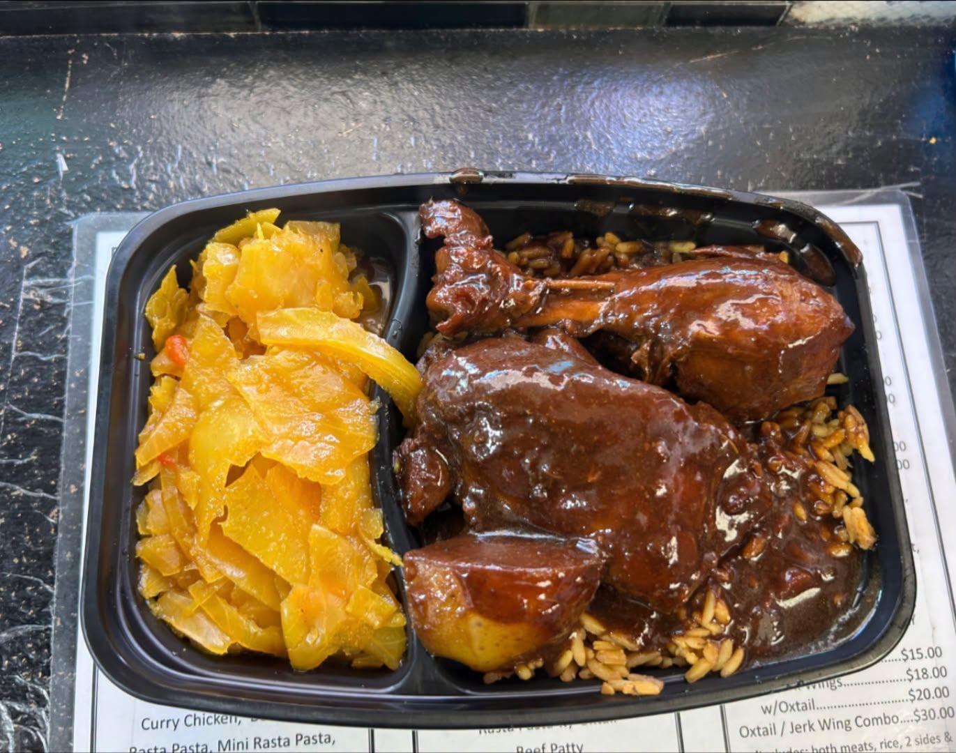 Brown stew chicken in rich brown gravy over rice with steamed cabbage