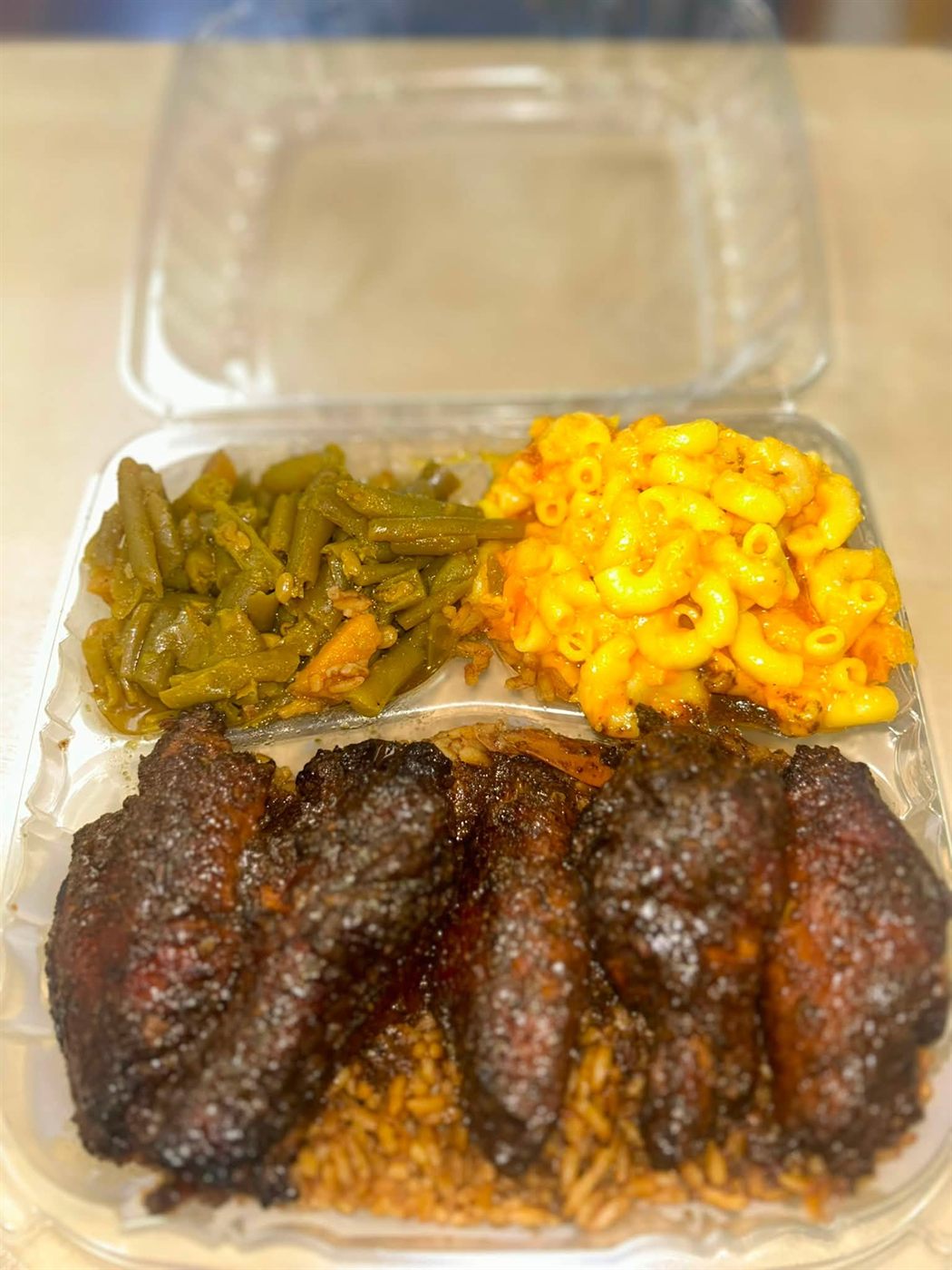 Jerk wings over rice with green beans and macaroni & cheese
